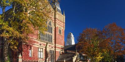 The University of Leeds Great Hall in autumn, with colourful trees and the Parkinson Building tower in the background.