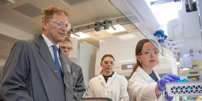 Grant Shapps, the Business Secretary, touring a lab at the Henry Royce Institute looking at equipment with two lab assistants.