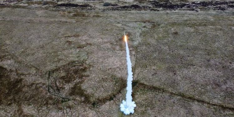 The Pathfinder rocket, taken from a drone, flying up in to the air, in the background is the Scottish mooreside.