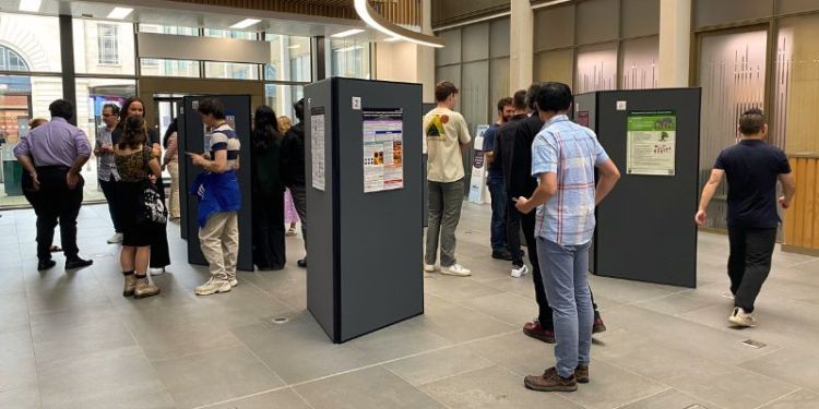 A candid shot of visitors looking at the poster competition in the Sir William Henry Bragg building foyer.