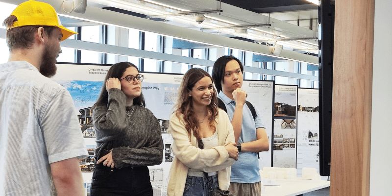 Students looking at their architecture projects on the MArch, MEng architecture course