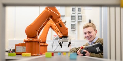Abb robot arm with male student