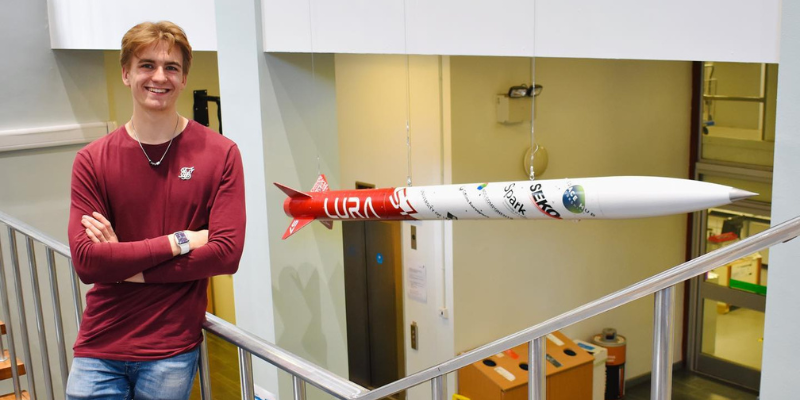 Theo Youds, Founder of Leeds University Rocketry Association with the Gryphon 1 hung in the School of Mechanical Engineering foyer