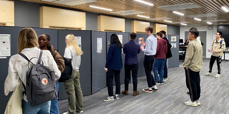 A photograph of a crowd of visitors looking at posters on display at the EPS Summer Internship scheme poster showcase.