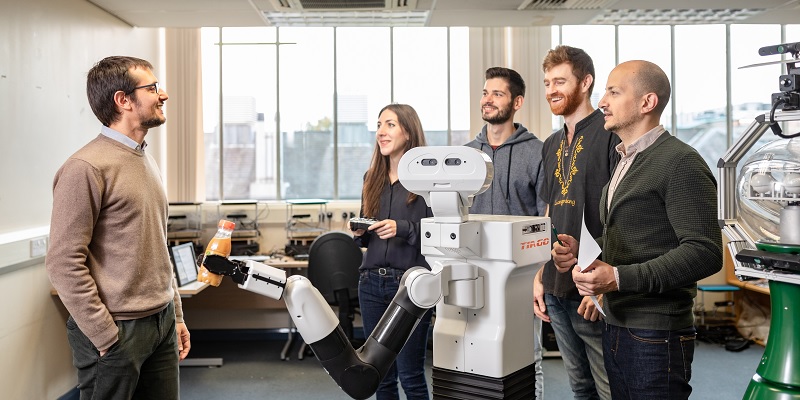 Dr Matteo Leonetti and PhD students with TiaGO robot