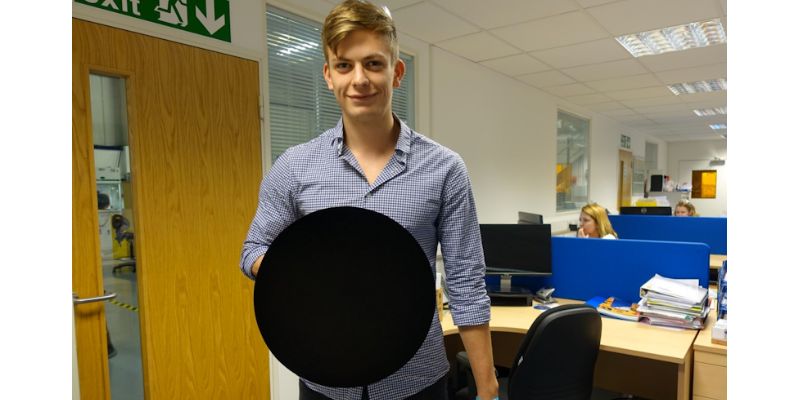 Student Will Ludlam holding a Vantablack-coated concave shield.