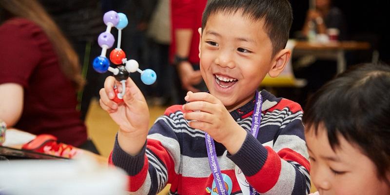 Kid holding a molecule model