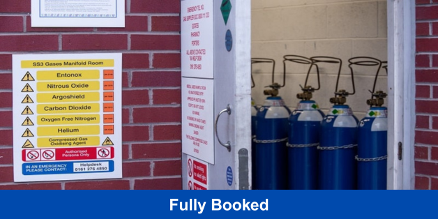 Gas manifold room with blue cylinders and safety sign; banner reads ‘Fully Booked’