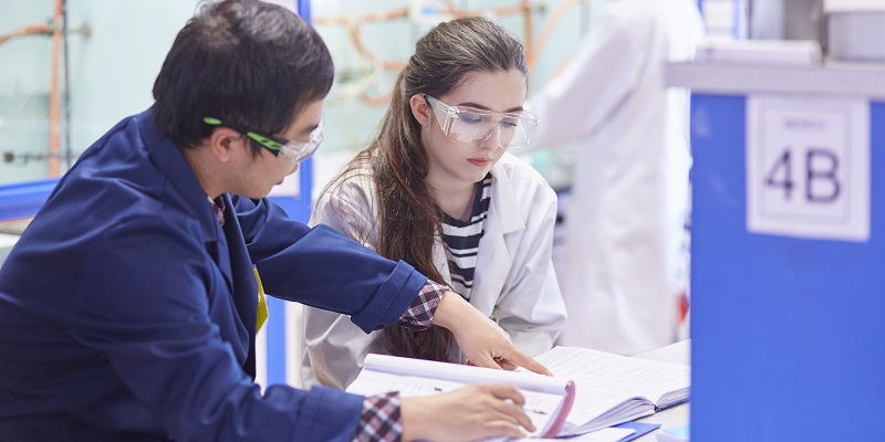 A chemistry teacher instructs a student in a laboratory class