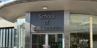 Entrance to the School of Mathematics building with signage above glass doors.