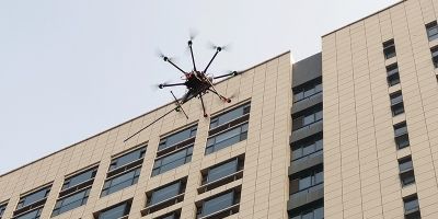 A drone flying by a building