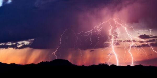 Storm clouds in a dusky red sky, with lightning bolts hitting the ground