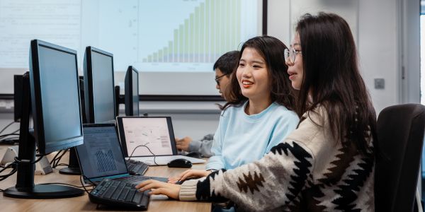 A computer cluster with three students looking at computers
