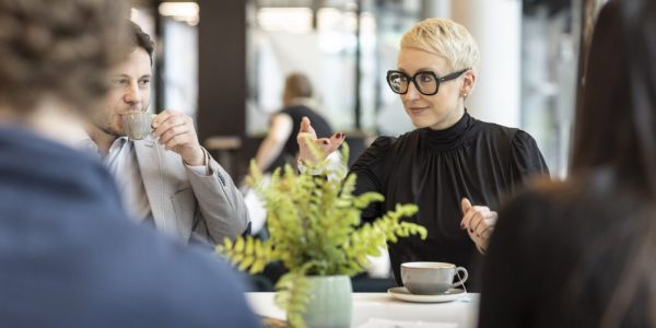 Professor Christine Unterhitzenberger having a coffee with others around a table