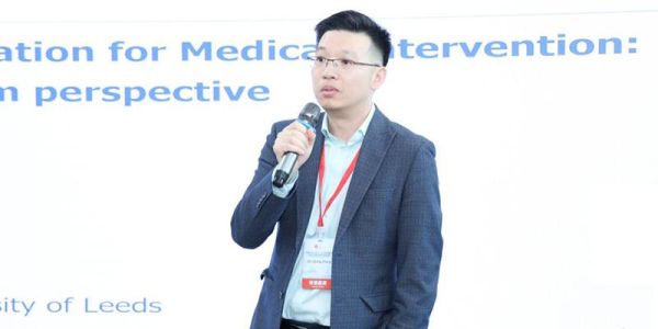 Picture of a man wearing a suit holding a microphone