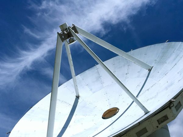 A large satellite array dish in front of a blue cloudy sky