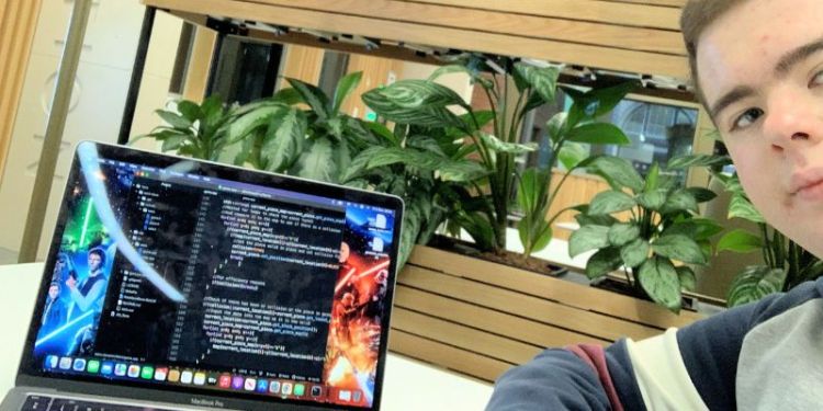 Computing student selfie in front of his laptop
