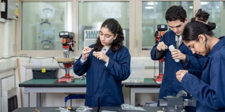 A photo of Ruqaiya Al Balushi and two other students in the Prototyping Workshop in the School of Mechanical Engineering.