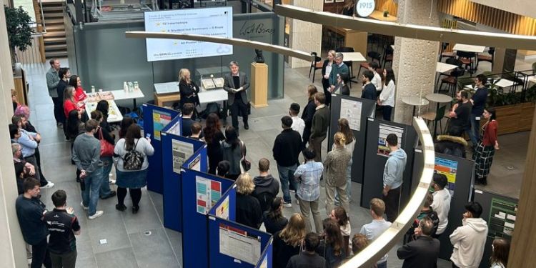 A birds eye view inside the atrium of the Bragg building. Poster displays and students and staff fill the room.