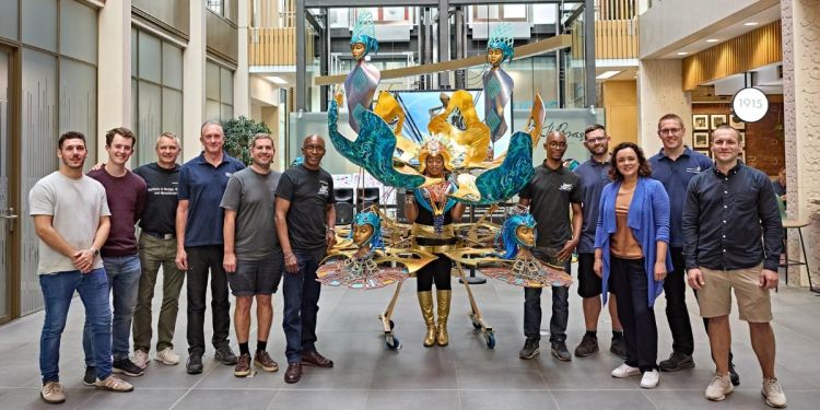 Mechanical engineering technicians standing around khadijah ibrahiim in the carnival costume