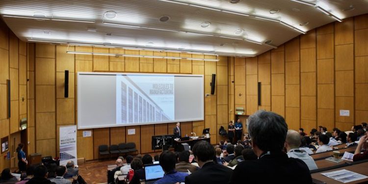 Lecture theatre seen from the last row, with attendees listening to a seminar