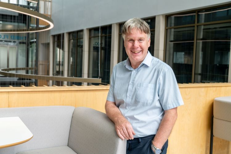 Professor Edmund Linfield stood beside a chair in the Bragg building.