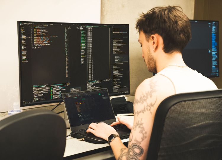 A person sitting at a computer coding at LeedsHack 2026