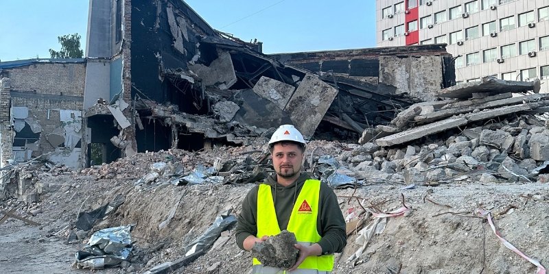 Professor Oleksii Hunyak, from Lviv Polytechnic National University, holding rubble in a bombed building in his country.