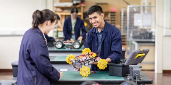Two students in the Mechanical Engineering workshop, working on a rover.