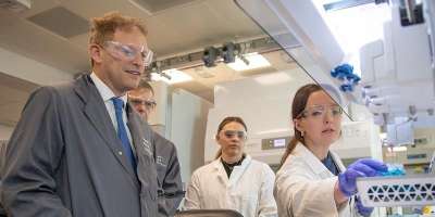 Grant Shapps, the Business Secretary, touring a lab at the Henry Royce Institute looking at equipment with two lab assistants.