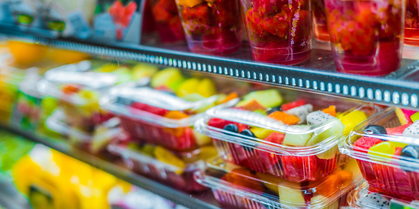 Fruit in plastic packaging on supermarket shelf