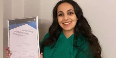 A photography of the Adam Neville Prize 2021 award winner, Deema Abu-Salma, a PhD student from Imperial College London, with her award.