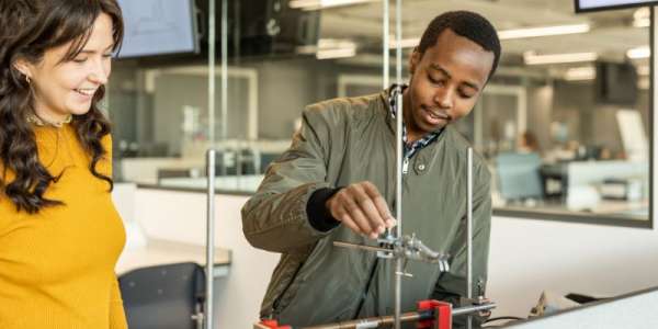 A physics student and their lecturer in the first year physics lab working on an experiment.