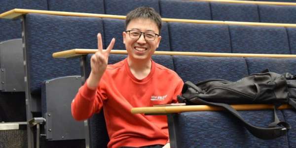 A portrait of Xiang Mao sat in a lecture theatre.